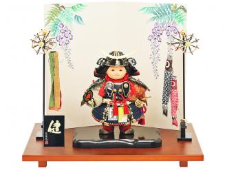「五月人形 健ちゃんシリーズ・健ちゃん(大鎧着) お祝い飾り」です。 当店・人形広場の工房(人形工房天祥)のオリジナルお五月人形は、人形職人の匠の“公司作”の手づくりのお人形です。 名匠・齊藤公司は、弊社・工房天祥の会長でもあり、経済産業省認定・岩槻人形伝統工芸士、埼玉県認定伝統工芸士、日本人形協会認定・節句人形工芸士です。 武者人形(子供大将)は、健やかなる男児に育って欲しいという願いが込められた、伝統的な節句人形飾りです。 正絹の本仕立て(紺糸威)の鎧を着用した元気いっぱいな子供らしさと優しいお顔が魅力の五月人形飾りです。 健ちゃんが着用している甲冑は、スタイリッシュな三日月形前立てが特徴的な人気の名匠・伊達政宗公モデルです。 また、兜には矧ぎ合わせ鉢という高度な技術を用いて、そして星鋲は一つ一つ手で植え込んだ高級仕様の兜です。 さらに、“藤の花”柄が描かれた、上品な屏風によって、格調高く仕上げています。