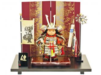 「五月人形 健ちゃんシリーズ・健ちゃん(大鎧着) お祝い飾り」です。 当店・人形広場の工房(人形工房天祥)のオリジナルお五月人形は、人形職人の匠の“公司作”の手づくりのお人形です。 名匠・齊藤公司は、弊社・工房天祥の会長でもあり、経済産業省認定・岩槻人形伝統工芸士、埼玉県認定伝統工芸士、日本人形協会認定・節句人形工芸士です。 武者人形(子供大将)は、健やかなる男児に育って欲しいという願いが込められた、伝統的な節句人形飾りです。 正絹の本仕立て(白絲褄取威)の鎧を着用した元気いっぱいな子供らしさと優しいお顔が魅力の五月人形飾りです。 また、“草花”柄の金彩加工がほどこされた塗り屏風によって、艶やかさが演出されています。 さらに、兜には矧ぎ合わせ鉢という高度な技術を用いて、そして星鋲は一つ一つ手で植え込んだ高級仕様の兜です。
