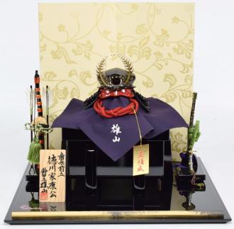 江戸甲冑師の匠　雄山作の徳川家康公兜のコンパクト飾りです。飾り台は漆器の産地で有名な富山県高岡地方の高岡塗です。屏風は、京唐紙の「秋唐草」柄です。