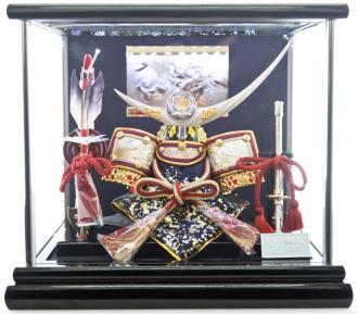 最強の戦国武将のとして名高い謙信の兜を模して作られており、アシンメトリーな鍬型が美しくデザイン性の高い兜です。
シックな黒塗枠のケースのバックにLEDライトを装備しています。
LED照明が彫金のバックや兜を彩ります。
飾りやすいケースつき