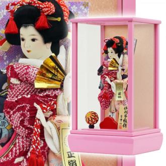 こちらの羽子板付き「彩春(ピンク)10号 正絹しぼり羽子板付」(かぶせケース入り)は、正絹しぼり仕立てと花柄のお袖が艶やかに華やいだ、代表的なスタイルの柄の一つである「道成寺」です。
能の演目の一幕を模した舞い姿の優美な印象で、「将来幸せになれますように・・・」という意味合いがあるものです。
また、まり飾りは女の子の初正月を祝う羽子板に添えられる事の多いお飾りですが、ただ華やかさを増すためだけでなく、「丸く健やかに美しく育つように」との願いが込められています。
お子様の幸せを願うご両親の想いが込められた、女の子のお守りとして受け継がれてきた日本の伝統的縁起物です。