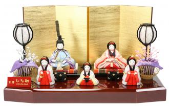 高貴で品格溢れるお衣装の親王様、光沢のある生地のお衣装が印象的です。清楚な印象の三人官女が可愛らしく寄り添います。光沢ある金屏風と溜色の飾り台が高級感を感じる飾りです。