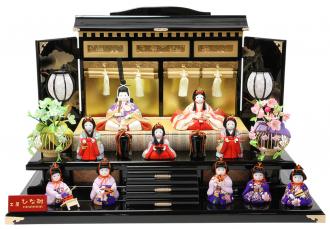 綺麗なお衣装の上品さと、高貴なお色と言われる紫の色合いが奥ゆかしさを感じる親王様に可愛らしい三人官女と賑やかな五人囃子。御殿飾り台がとっても豪華で品格を感じる飾りです。